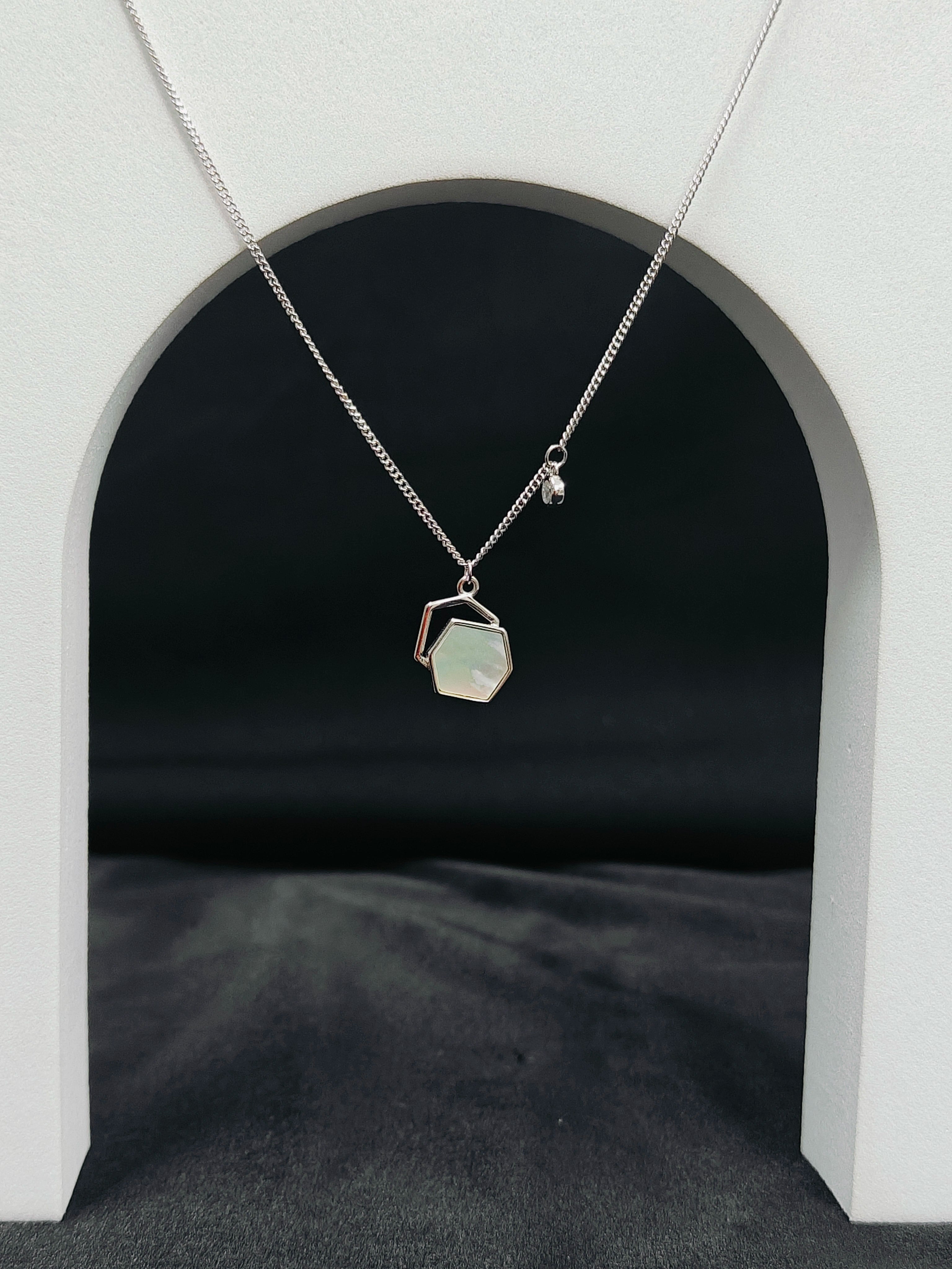 Necklace with a pendant hanging from an archway